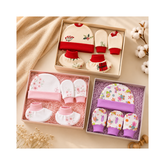 Set of baby booties, hats, and mittens in decorative boxes on a soft beige background.